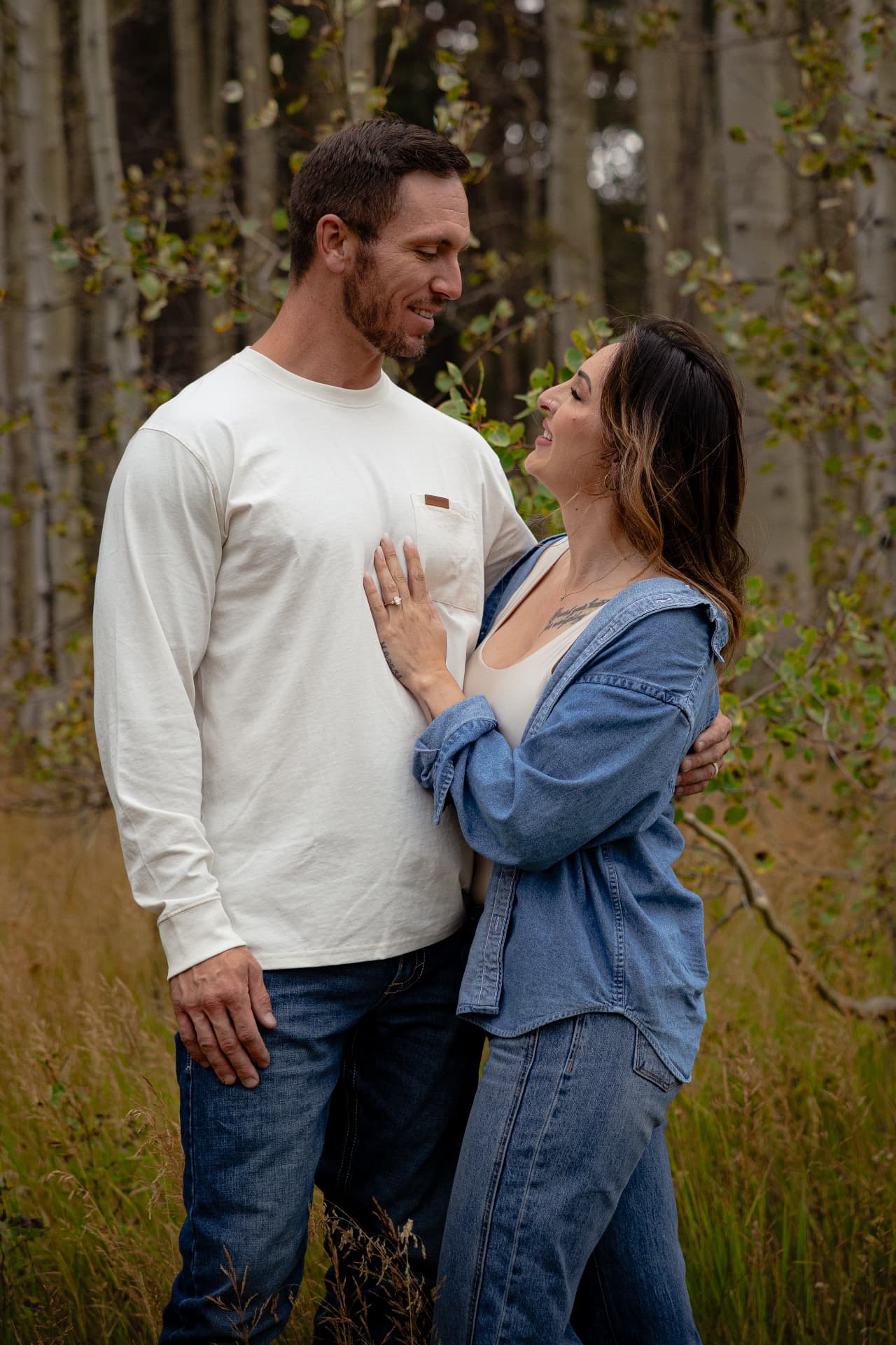Couple laughing together in an aspen grove